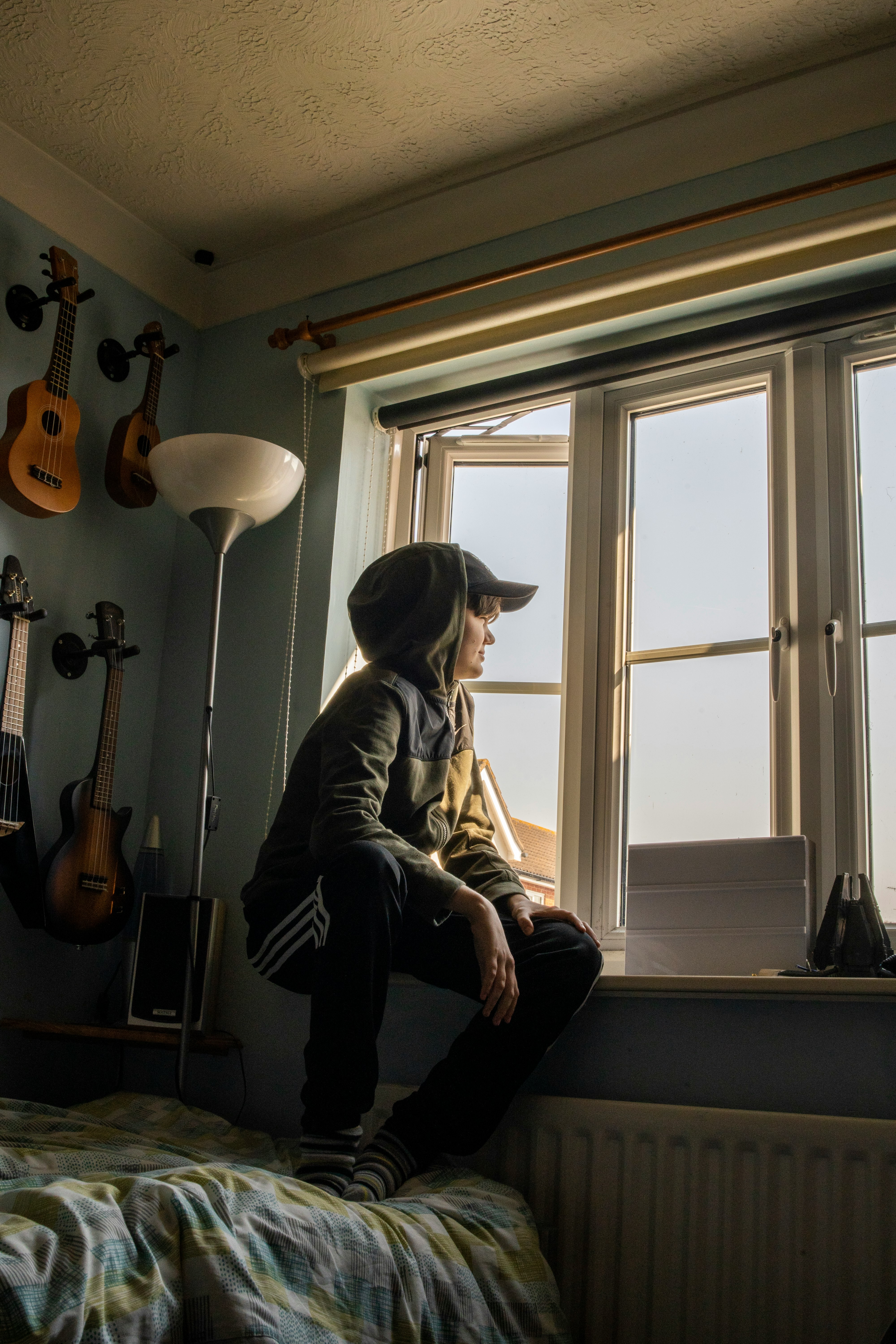 man in gray jacket sitting on chair beside window